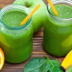 Zwei Gläser grüner Smoothie, ein ideales green drink rezept, mit Spinat, Apfel, Orange, Banane und Kiwi.
