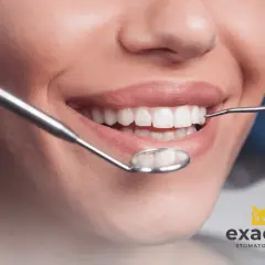 Uśmiechnięta pacjentka podczas wizyty w Exacto Stomatologia. Dentysta bada jej zdrowe zęby.