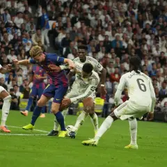Zacięta walka o piłkę na boisku podczas rozgrywek La Liga. Piłkarze Realu Madryt i Barcelony walczą o dominację.