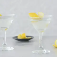 Dwa eleganckie drinki z martini, ozdobione skórką cytrynową, czekają na spróbowanie.
