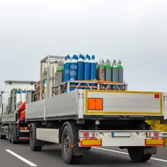 Ciężarówka z butlami gazowymi, klasa 2 ADR, jedzie autostradą.