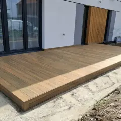 Nowy taras na słupach betonowych, wykonany z desek kompozytowych, stanowi idealne przedłużenie domu.