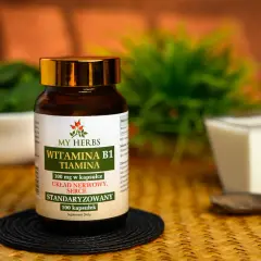 Butelka suplementu "Witamina B1 Tiamina" od My Herbs, wspierająca układ nerwowy i serce. Obok miseczka z jogurtem i łyżka.