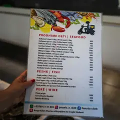Menu z daniami z **albania jedzenie** – owoce morza, ryby i wino.