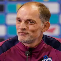 Thomas Tuchel, były trener Chelsea, w bordowej kurtce z niebieskimi wstawkami, z przypinką w kształcie niebieskiego kwiatka.