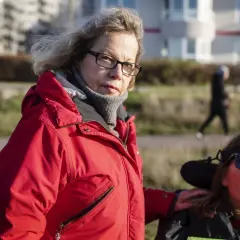 Catrin Hedlund Seyhan med handen på en kvinna i rullstol utomhus.
