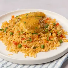 Plato de arroz con pollo, zanahorias, guisantes y pimientos rojos. Una deliciosa receta de arroz con pollo lista para servir.