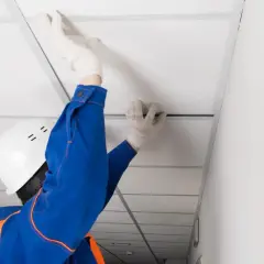 Pose d'un faux plafond dans un garage, améliorant l'isolation et l'esthétique.