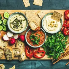 Deska przekąsek z dwoma rodzajami hummusu, warzywami, pieczywem i paluszkami. Co to jest hummus? To pyszna pasta z ciecierzycy.