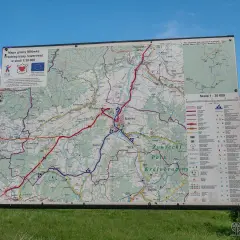 Mapa gminy Milówka pokazuje przebieg niebieskiego szlaku rowerowego. Widać liczne drogi i ścieżki, a także legendę z symbolami.