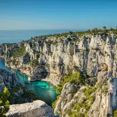 Vue spectaculaire depuis le belvédère d'En Vau sur la calanque aux eaux turquoise, entourée de falaises calcaires et de pins.
