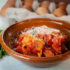 Frittata in trippa, un piatto saporito con uova e trippa in salsa di pomodoro, guarnito con parmigiano.