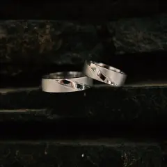 Dwa srebrne pierścionki na ciemnym tle. Białe złoto czy żółte które droższe?