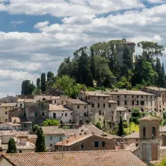 Panoramica di Cetona, un borgo toscano con case in pietra e tetti in cotto, dominato da una torre antica. Cosa vedere in questo incantevole paesaggio.