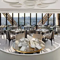 Un restaurant cool pour ado avec vue panoramique sur Paris. Tables dressées, sièges confortables, ambiance chic.
