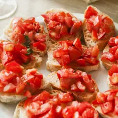 Bruschettas appétissantes, parfaites pour une recette facile. Des tranches de pain grillé garnies de tomates fraîches et d'herbes.