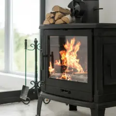 Poêle à bois crépitant, optimisant le pouvoir calorifique du pellet pour une chaleur réconfortante. Un ventilateur et du bois sont prêts à l'emploi.