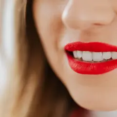 Labios rojos vibrantes y una sonrisa deslumbrante.