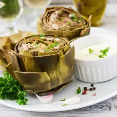 Artichauts entiers, tendres et savoureux, prêts pour la cuisson vapeur. Servis avec une sauce crémeuse et des herbes fraîches.