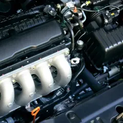 Motor de coche con colectores de admisión plateados y cubierta negra. El hp motor está listo para la acción.