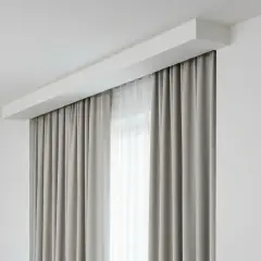Nowoczesna wnęka na karnisz w suficie podwieszanym, z zasłonami tworzącymi elegancką ramę okna.