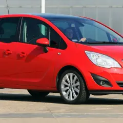 Czerwony Opel Meriva B z czarnym dachem, widziany z przodu z boku.
