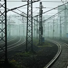 Mglisty poranek na teren na tor kolejowy. Wiele torów i słupów trakcyjnych tworzy labirynt.