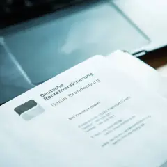 Brief der Deutschen Rentenversicherung Berlin-Brandenburg liegt auf einem Laptop. Hoffentlich bedeuten die Schreiben, dass die renten steigen.