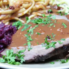 Sauerbraten rezept: Zarte Scheiben Braten mit dunkler Soße, dazu Rotkohl und Spätzle. Ein Klassiker der deutschen Küche.