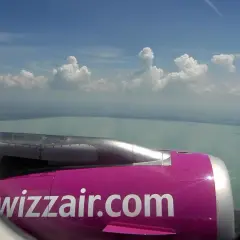 Widok z okna samolotu Wizzair na jezioro i chmury. Zastanawiasz się, ile kosztuje wybór miejsca w Wizzair?