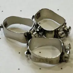 Trzy metalowe pierścienie aparat ortodontyczny, błyszczące i gotowe do pracy nad uśmiechem.
