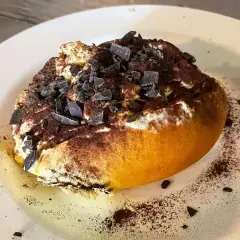 Un dolce al cucchiaio, soffice e cremoso, cosparso di cacao e scaglie di cioccolato. Un assaggio di cosa si mangia a Roma, un'esperienza da non perdere.