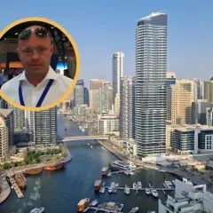 Mężczyzna w okularach na tle Dubaju. Dowiedz się, ile kosztują mieszkania w Dubaju i jakie są ceny nieruchomości w tym mieście.