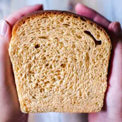 En skiva gyllene bröd, perfekt för en frukost istället för sirap. Hålls varsamt i två händer.