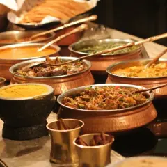 Bogactwo smaków: aromatyczne jedzenie indyjskie w miedzianych naczyniach. Curry, ryż i przyprawy kuszą zmysły.