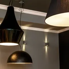 Varias lámparas de techo negras cuelgan, iluminando la estancia con un brillo cálido.