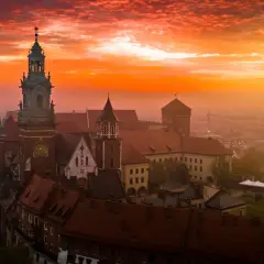 Wawel o wschodzie słońca, z ognistym niebem i mgłą unoszącą się nad miastem. Czuć energię czakramu wawelskiego.