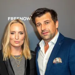 Patryk Mikiciuk z żoną na ściance. Elegancka para pozuje do zdjęć.