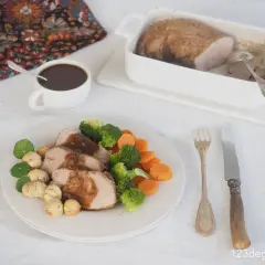 Tranches de filet mignon, accompagnées de légumes verts et de carottes, nappées d'une sauce savoureuse. La cuisson parfaite du filet mignon est mise en valeur.
