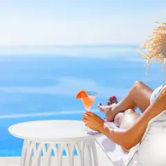 Kobieta w słomkowym kapeluszu relaksuje się z drinkiem przy basenie. Idealny all inclusive soft.