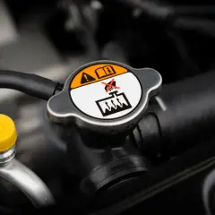 Tapa del radiador con advertencias. Es normal que un coche consuma anticongelante, pero revisa el nivel.