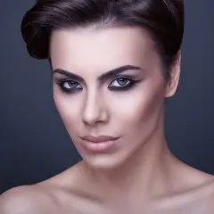 Volto di donna con trucco drammatico, labbra carnose e occhi all'ingiù che catturano lo sguardo.