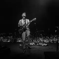 Asaf Avidan spielt in Berlin. Ein Mann mit Gitarre auf der Bühne, das Publikum im Hintergrund.