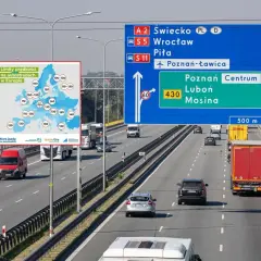 Jazda z przyczepą po autostradzie A2 w kierunku Poznania. Obok tablica z limitami prędkości w Europie.