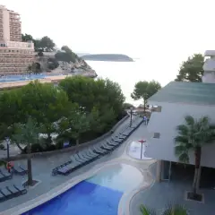 Resort con piscina y tumbonas junto al mar, con vistas a la costa de occidental cala viñas.