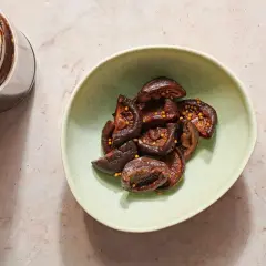 A jar and bowl of glistening pickled shiitake mushrooms, studded with mustard seeds.