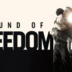 Sound of Freedom" Stream: Ein Mann umarmt ein Kind, während ein Polizist daneben steht.