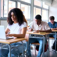 Uczniowie w klasie, jeden pisze, drugi na laptopie. Do jakiej szkoły średniej trzeba iść żeby zostać prawnikiem? To pytanie zadają sobie młodzi ludzie, którzy marzą o karierze w prawie.