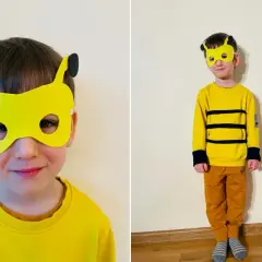Chłopiec w żółtej masce pszczoły i stroju z czarnymi pasami.