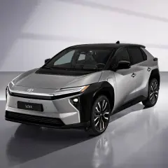 Srebrny Toyota bZ4X z czarnym dachem, gotowy na długie podróże. Ten elektryczny SUV oferuje imponujący zasięg.
